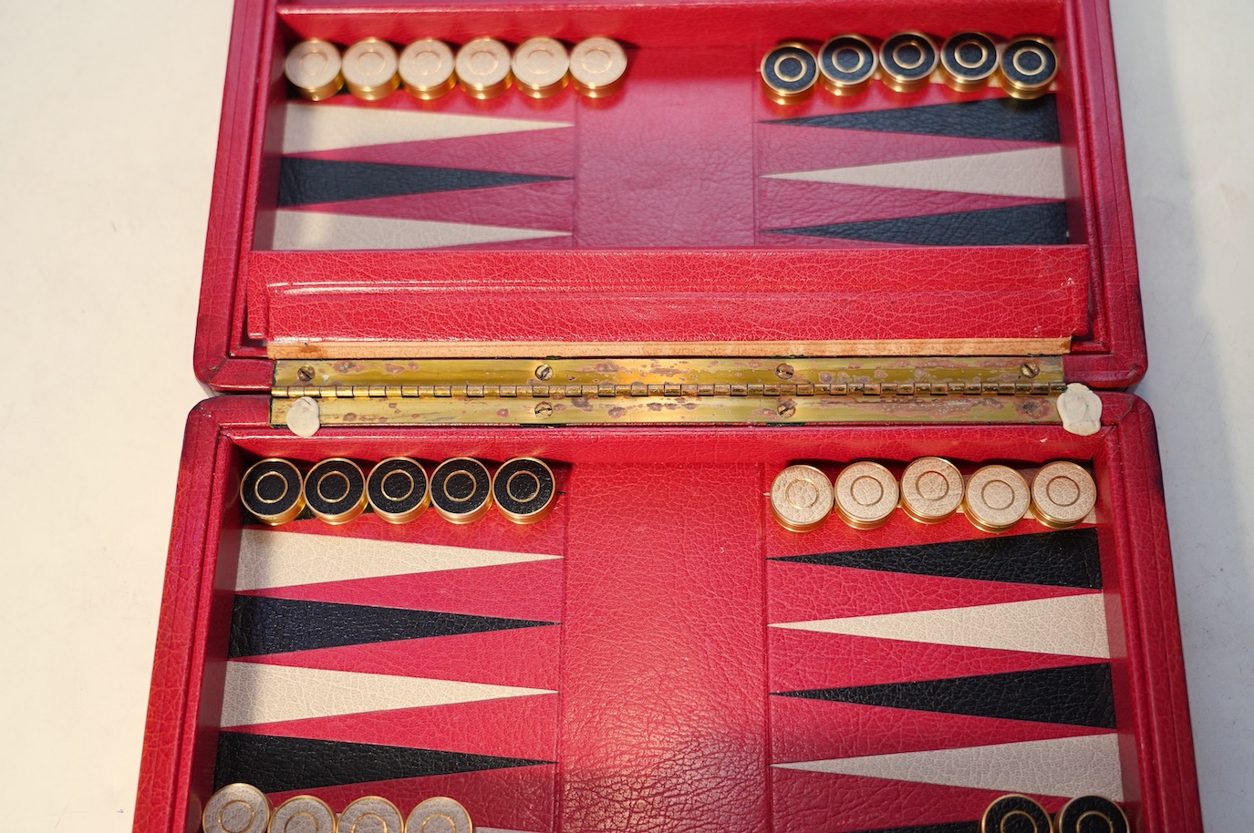 A Geoffrey Parker red leather backgammon set and a black leatherette wrist watch case